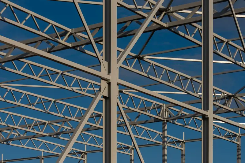 Steel roof trusses and framing against a blue sky
